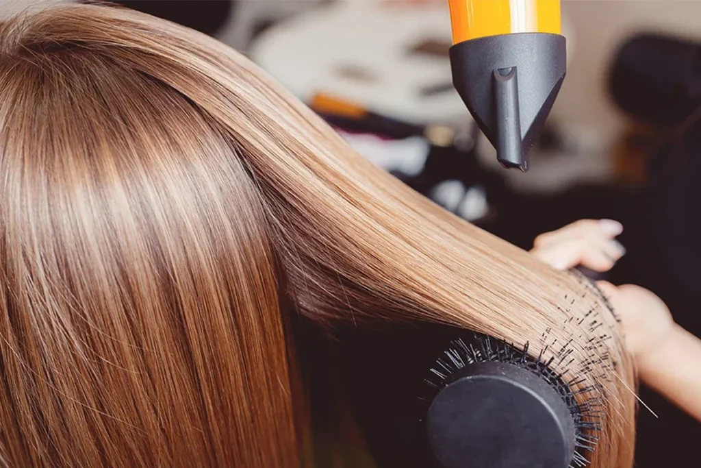 Close-up of a blow dryer styling straight hair