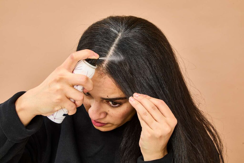 Person applying hair product to the roots for hair care