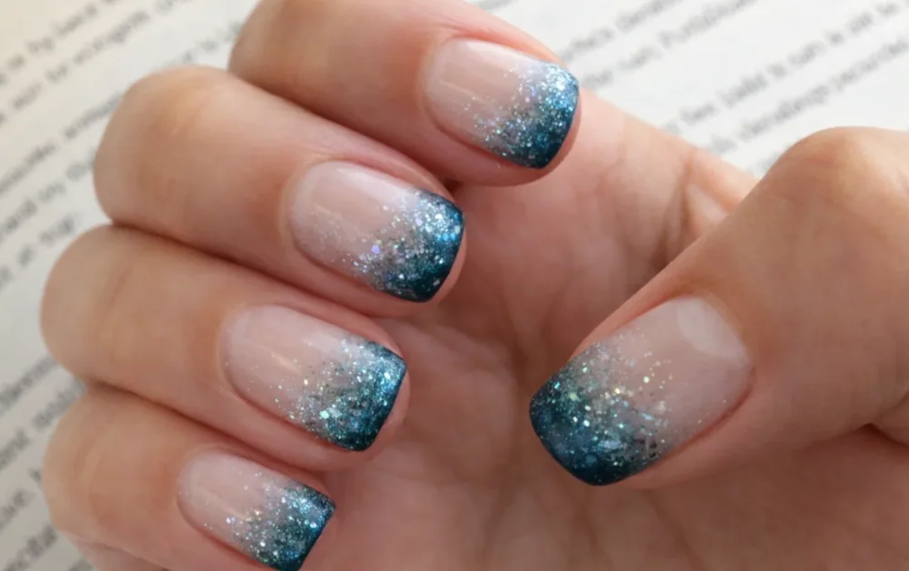 Short square nails with blue glitter ombré tips on a natural base.